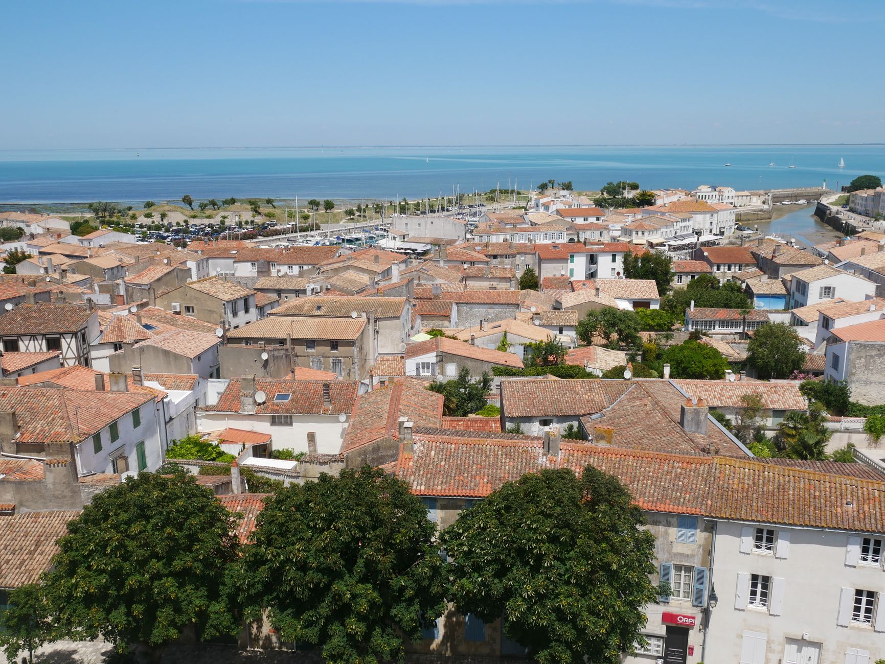 Vue aérienne d'un village de l'île de Ré avec ses maisons blanches et toits de tuiles, face à la mer
